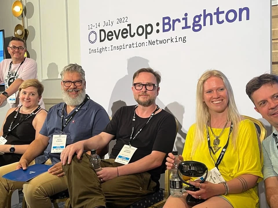 Ali Durrant with other attendees beside the Develop:Brighton 2022 event banner.